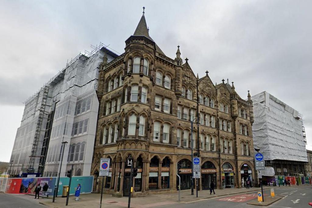 A view of the the Estate Buildings from street level. The building is four-storey's tall and has several spires on its roof.