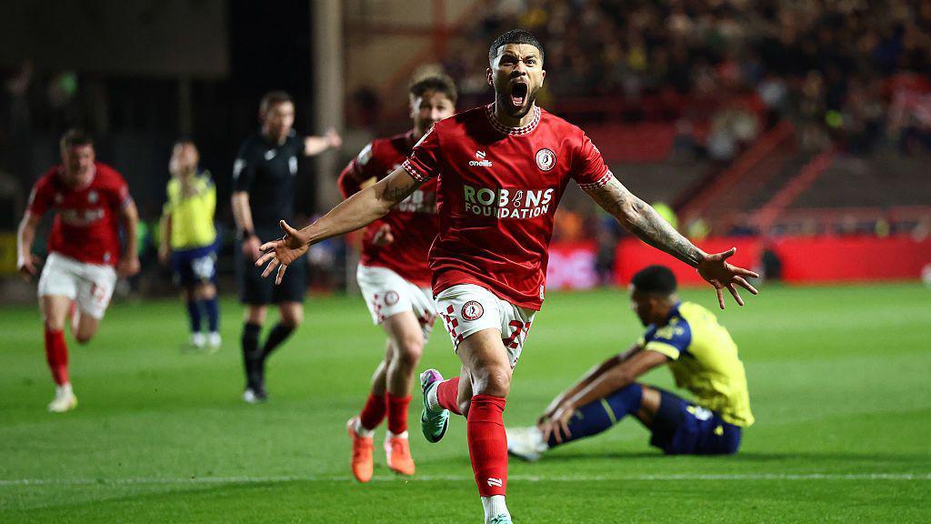 Nahki Wells runs with his arms out to celebrate his goal