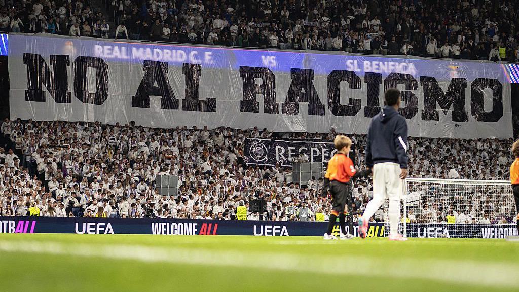 A banner with the words "no to racism" in Spanish is displayed before Real Madrid's game with Benfica at the Bernabeu