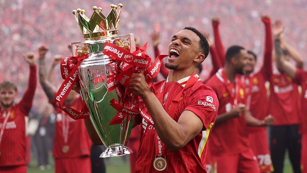 Trent Alexander-Arnold smiling and lifting the Premier League trophy last weekend.