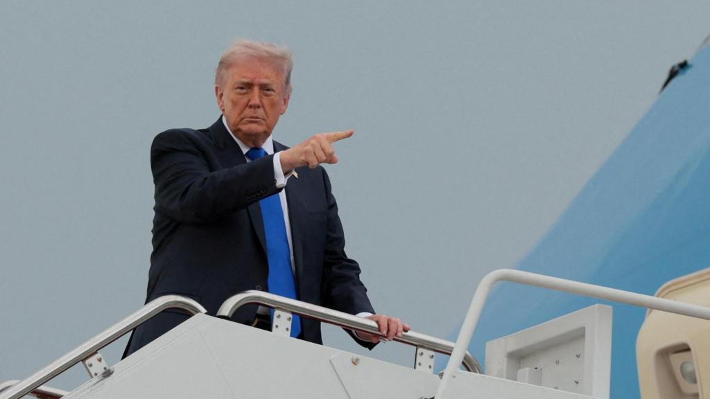 Donald Trump standing at top of plane steps