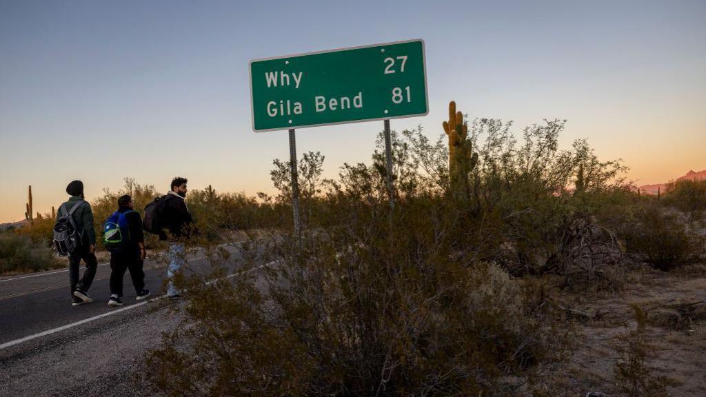 Immigrants from India walk into the United States after crossing the US-Mexico border on 7 December 2023 in Lukeville, Arizona.