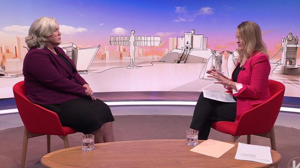 Heidi Alexander (L) sitting down on a red chair in a TV studio as she listens to Laura Kuenssberg (R), also sitting on a red chair, asking her a question