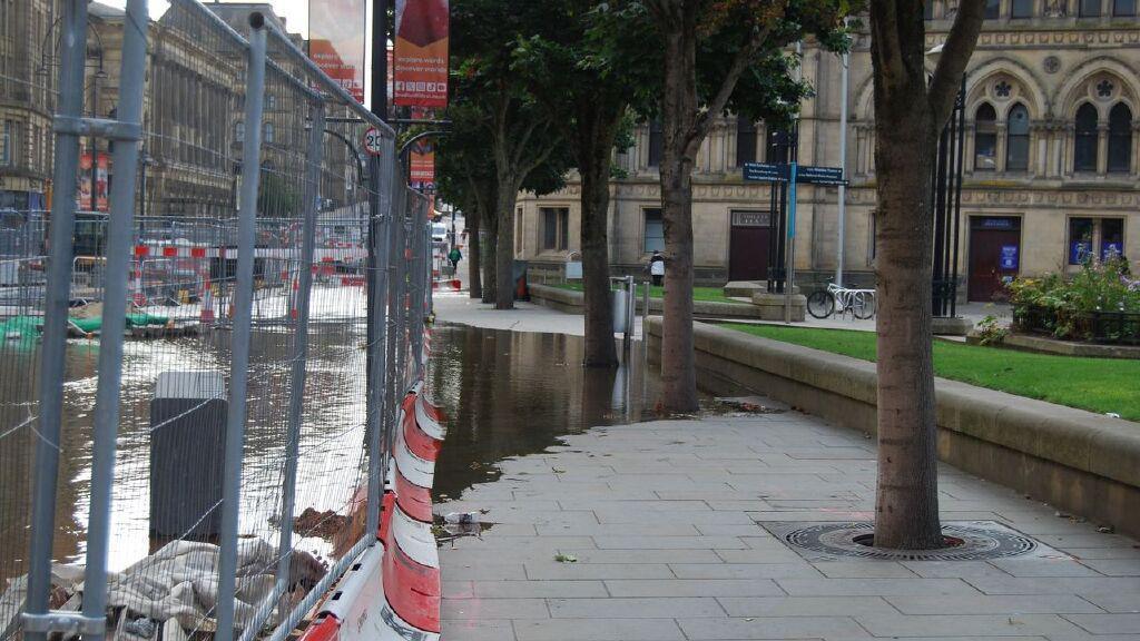 Water flooding across paving on Bridge Street next to Centenary Square 