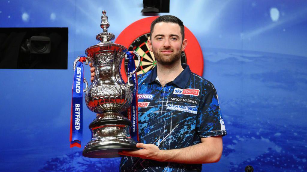 Luke Humphries holding the 2024 World Matchplay Darts title