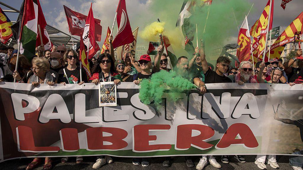 People are seen in Naples during a national transport strike called by a grassroots union - holding a big banner that reads "Free Palestine"