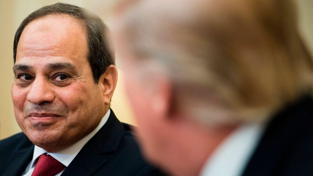 US President Donald Trump (in foreground, out of focus) listens while Egypt's President Abdel Fattah el-Sisi makes a statement