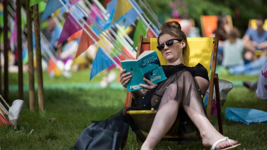 A woman reading a book at Hay Festival