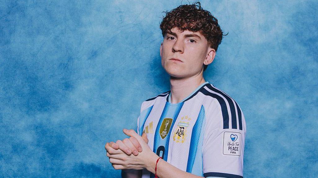 Valentin Barco clasping his hands together in a photoshoot for Argentina
