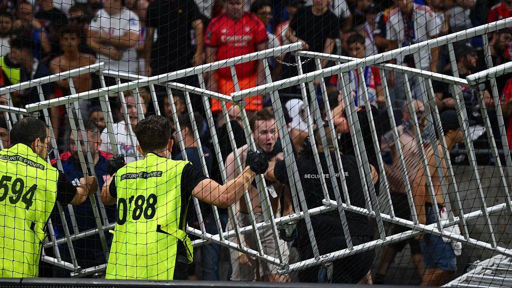 Lyon fans are marshalled by stewards