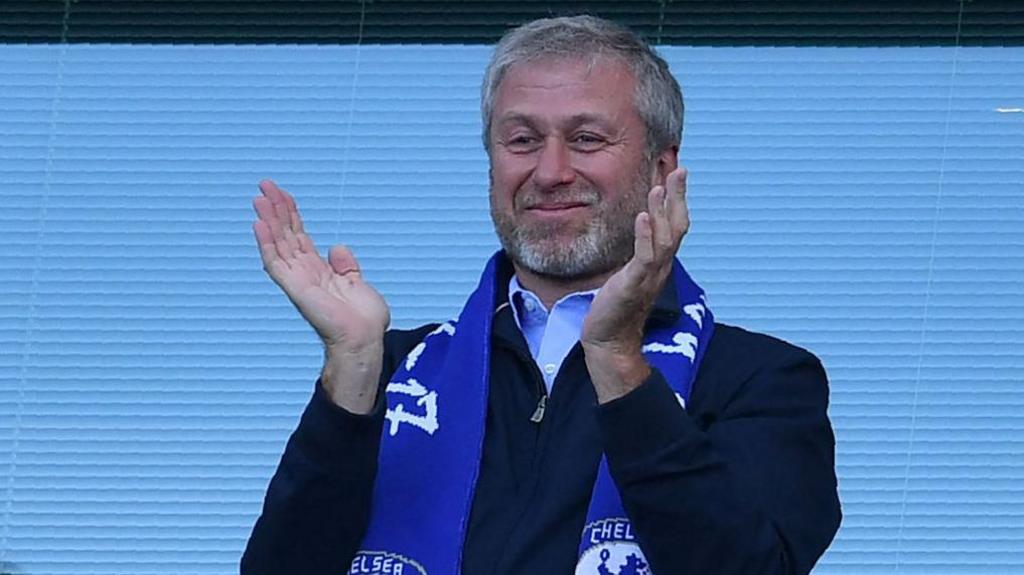 Roman Abramovich claps whilst wearing a Chelsea scarf