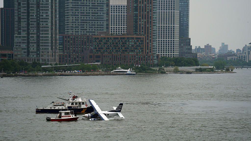 Emergency services respond to a crashed seaplane in the East River on 5 July in New York City.

