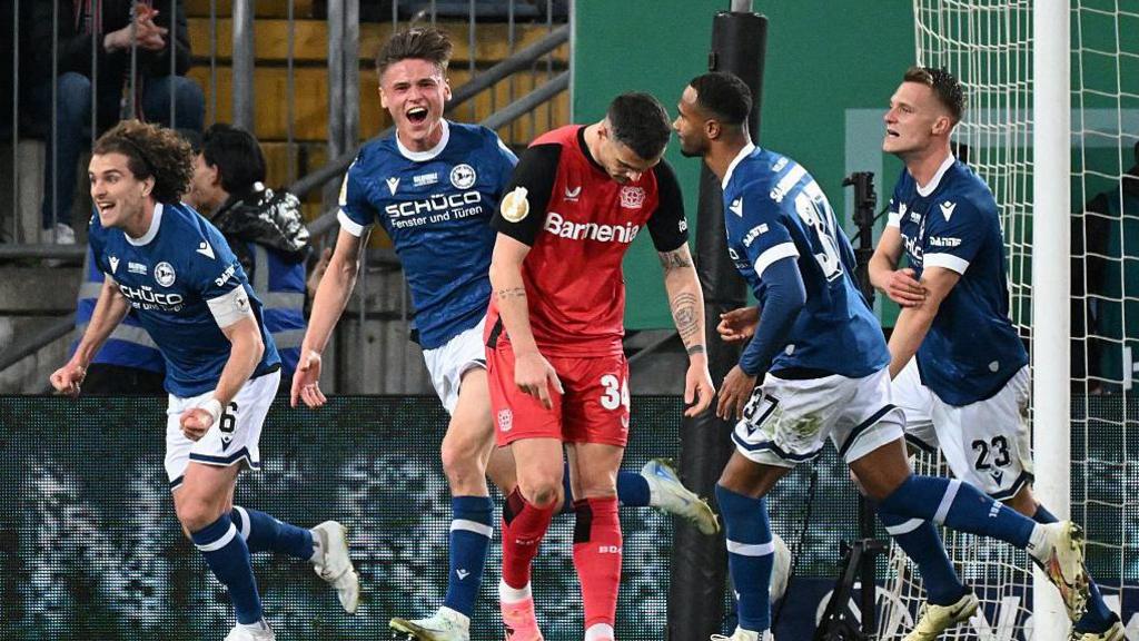 Arminia players celebrate after scoring against Leverkusen