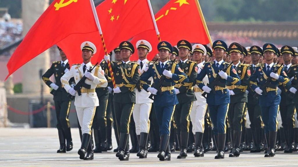 A guard of honour carries the Chinese flag