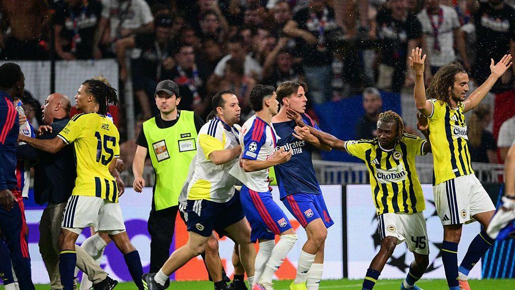 Matteo Guendouzi holds his hands up as Lyon players confront him