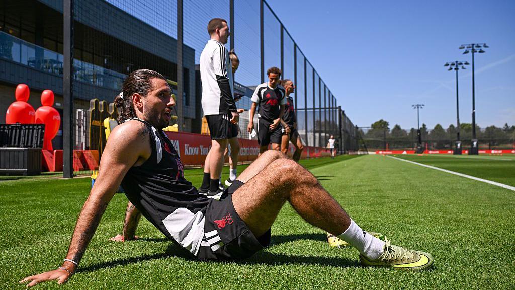 Dominik Szbozslai sits on the turf during training