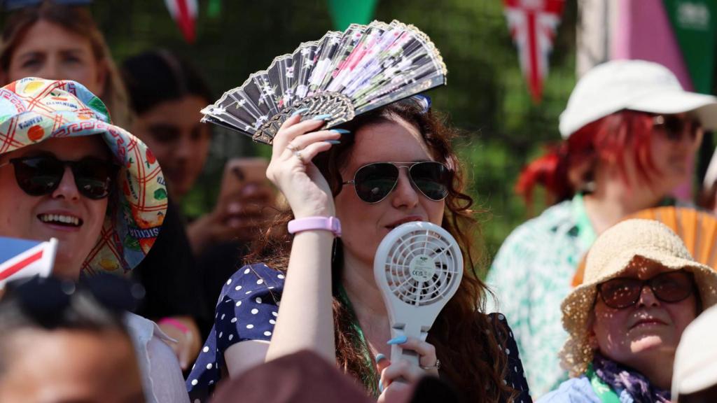 A visitor to London Zoo uses an electric fan to cool herself from the hot weather in London, Britain, 09 July 2026
