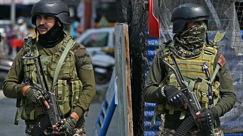 Indian paramilitary personnel stand guard along a road in Srinagar on May 7, 2025, following border tensions. India and Pakistan exchanged heavy artillery along their contested frontier on May 7, after New Delhi launched missile strikes on its arch-rival in a major escalation between the nuclear-armed neighbours. New Delhi announced it had carried out "precision strikes at terrorist camps" at nine sites in Pakistan-administered Kashmir, days after it blamed Islamabad for a deadly attack on the Indian-run side of the disputed region. (Photo by Sajjad HUSSAIN / AFP) (Photo by SAJJAD HUSSAIN/AFP via Getty Images)