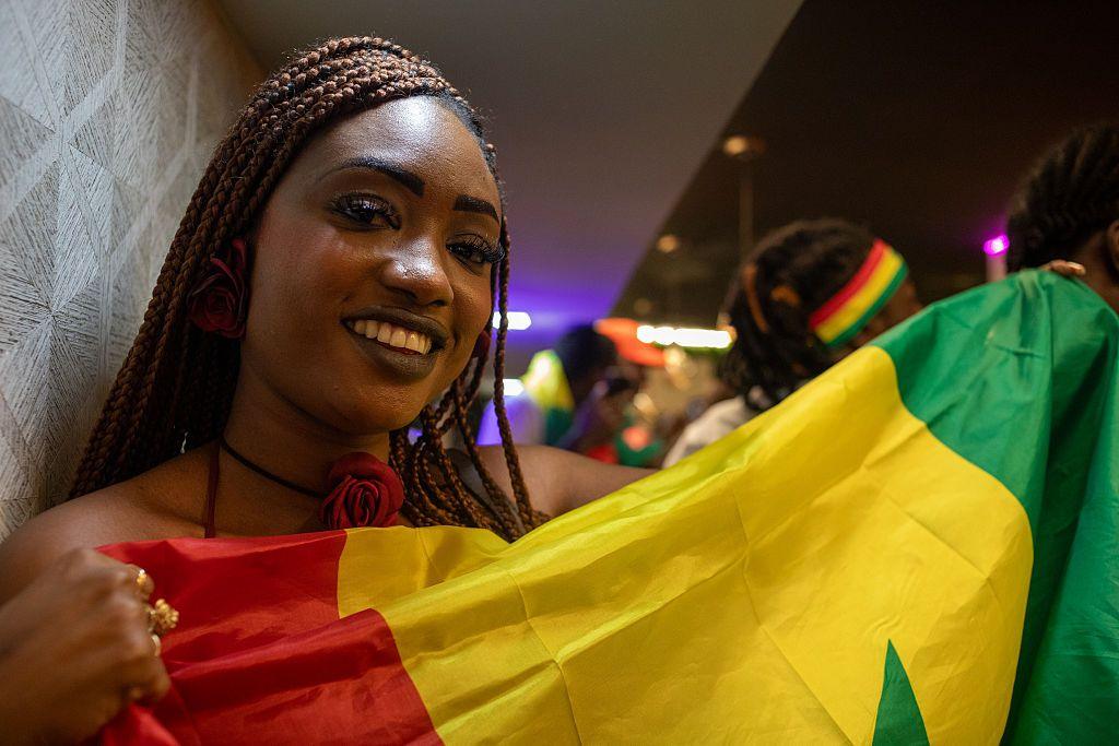 A close up shot of a woman holding a Senegal flag.