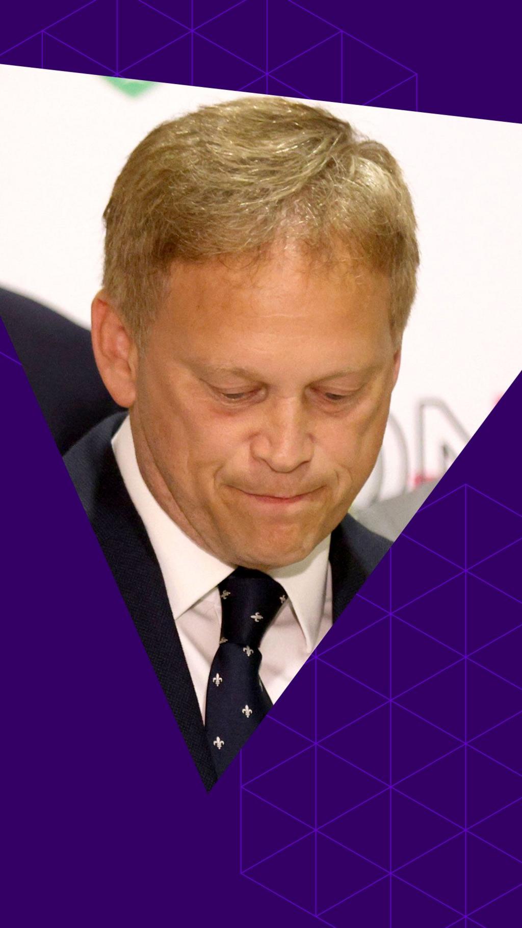 Grant Shapps looks down as he speaks, with lips pursed