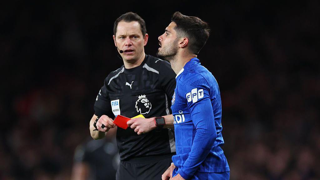 Pedro Neto looks to the sky as referee Darren England gives him a red card