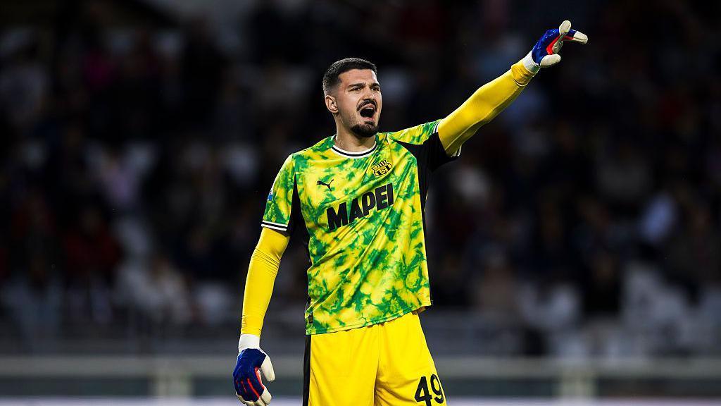 Arijanet Muric in a yellow Sassuolo goalkeeping kit shouts at his defenders during a game
