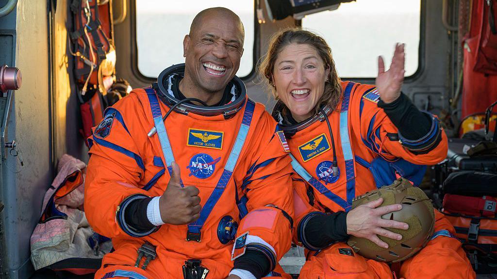 Victor Glover and Christina Koch smiling after landing back on Earth.
