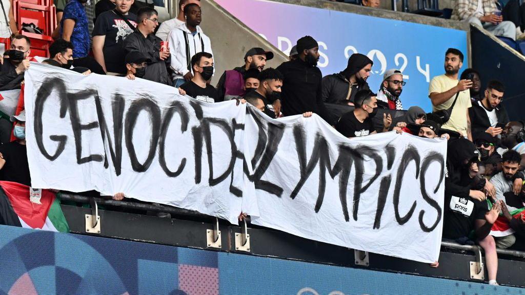 A banner reading "Genocide Olympics" was displayed by fans at the Parc des Princes during Israel's match against Paraguay