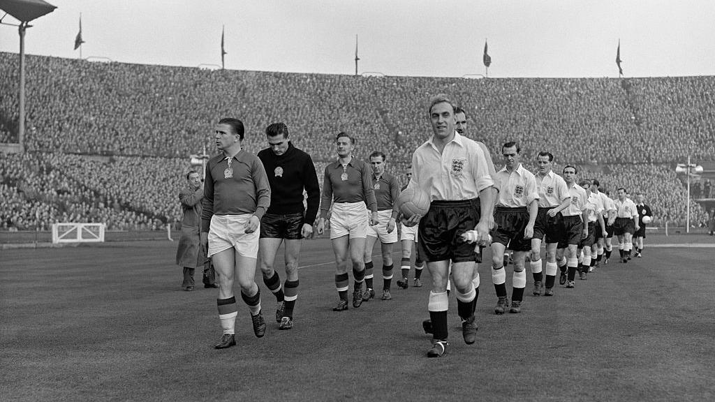Ferenc Puskas (front left) leads Hungary out onto the pitch at Wembley with England captain Billy Wright (front right).