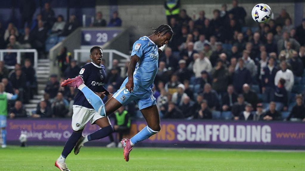 Haji Wright is in mid-air after nodding home Coventry City's second goal of the night at the New Den