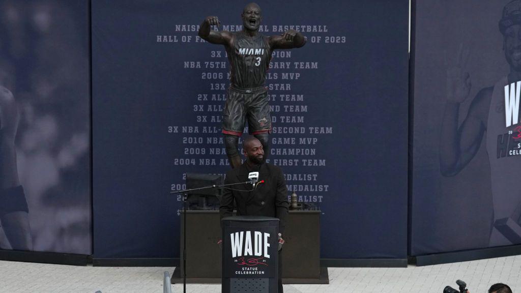 Wade in front of the statue of him