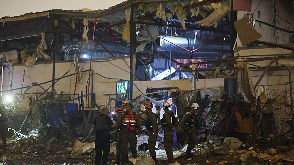 Israeli security forces and first responders inspect the site of an Iranian strike that hit a residential neighbourhood in Petah Tikva on April 2, 2026