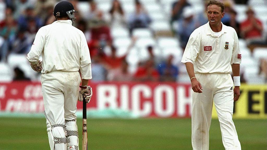 Bowler Allan Donald looks sternly at batsman Michael Atherton in front of rows of spectators at Trent Bridge