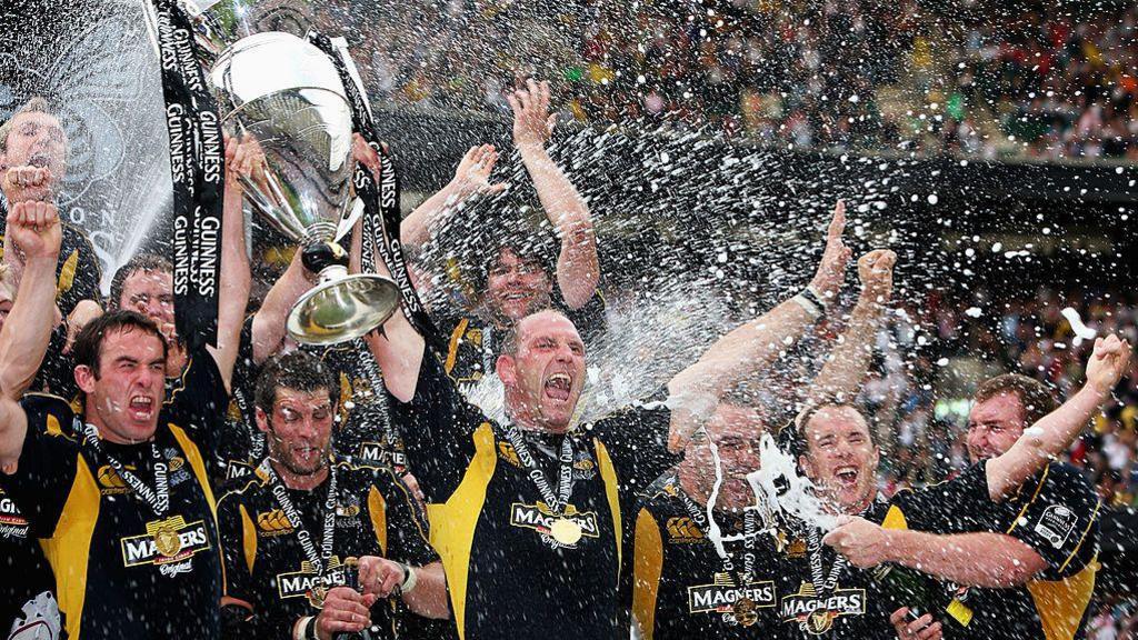 Lawrence Dallaglio, centre, and Wasps players hold the Premiership trophy aloft to celebrate while being showered in champagne