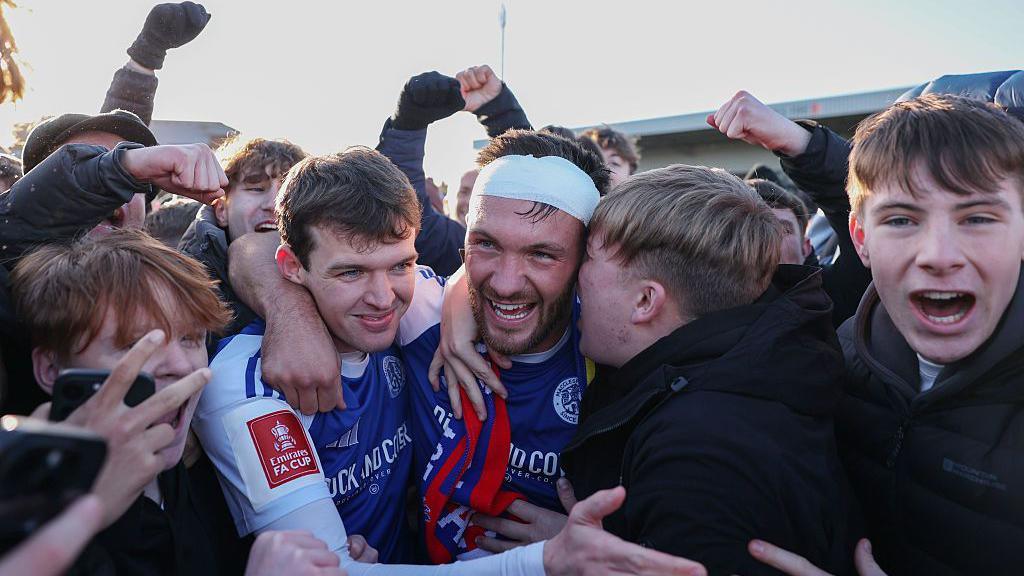 Paul Dawson and Luke Duffy celebrate with fans after the team's FA Cup victory v Crystal Palace.
