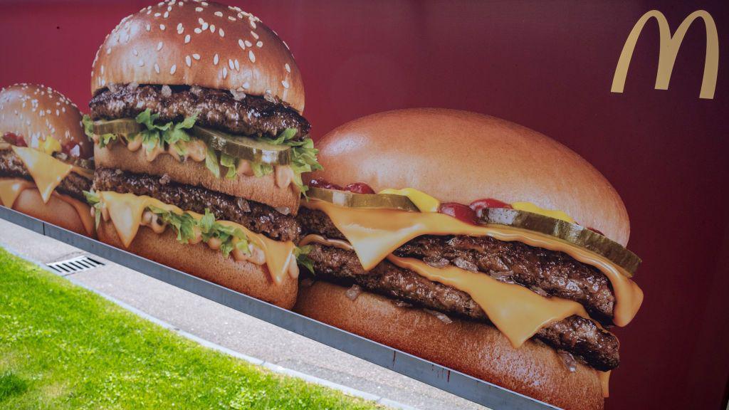 An advertising hoarding featuring two large multi-layered cheeseburgers