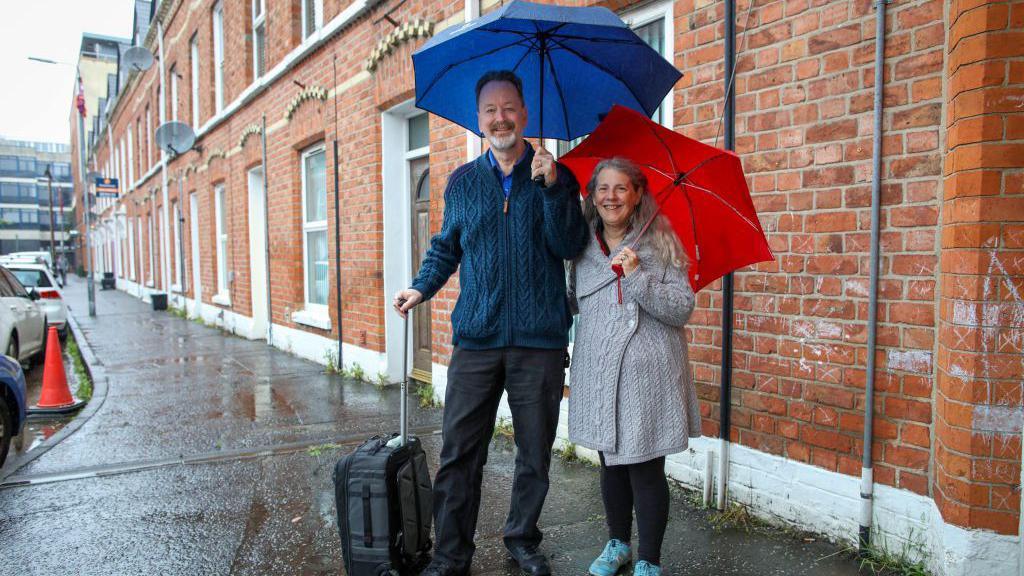 Randy and Kit Cassingham from Colorado, USA, pose for a photograph outside the rented apartment in south Belfast, on September 26, 2024, which has been their home since May due to delays with the Villa Vie Residences' 'Odyssey' cruise ship