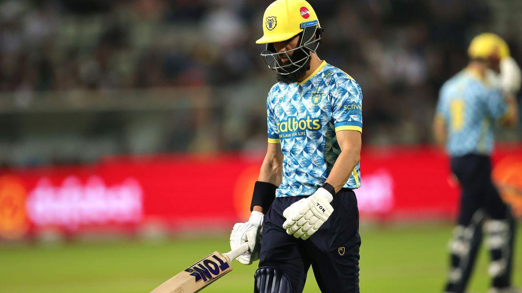 Moeen Ali on his way back to the Edgbaston pavilion after getting out to Gloucestershire's David Payne