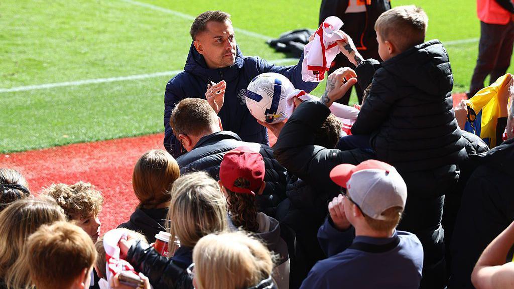 Southampton head coach Tonda Eckert signs autographs for fans