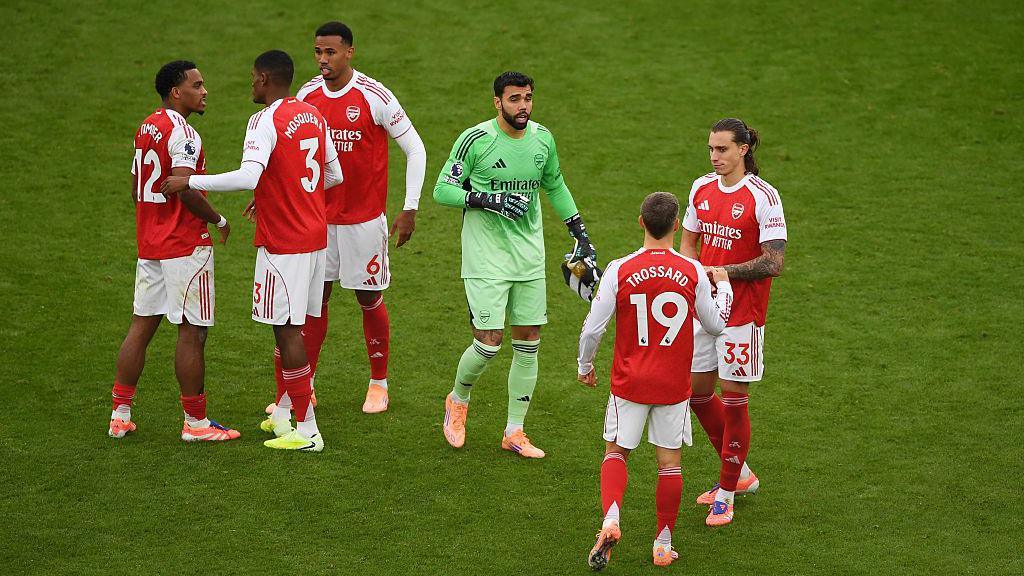 Arsenal players chat before a game on the pitch