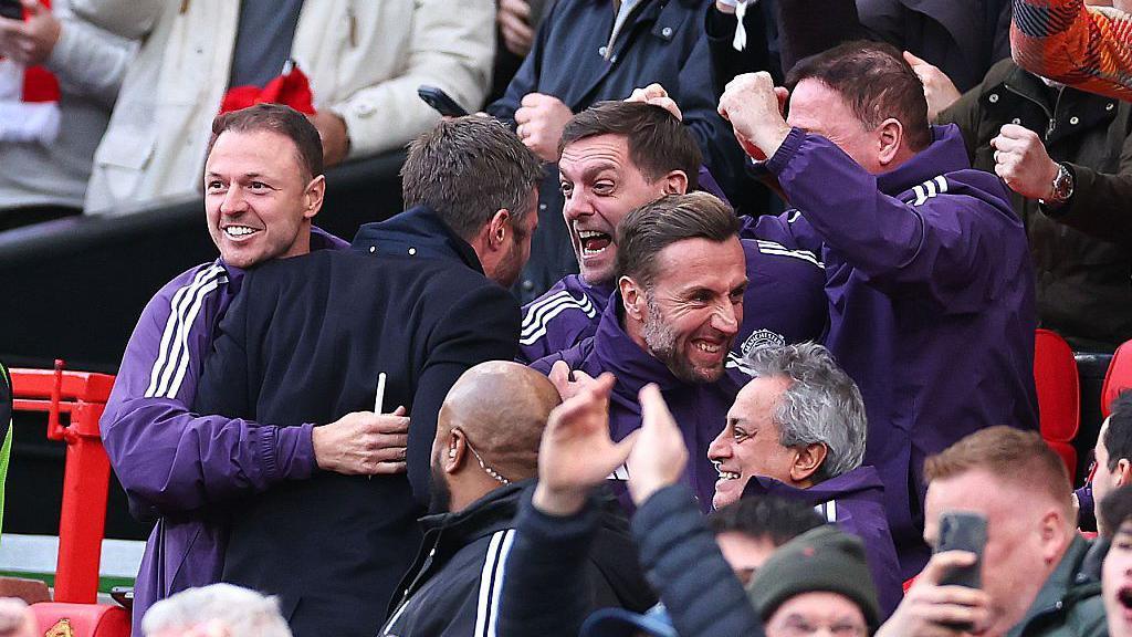 Carrick (second from left) celebrates United's second goal against City with his coaching team