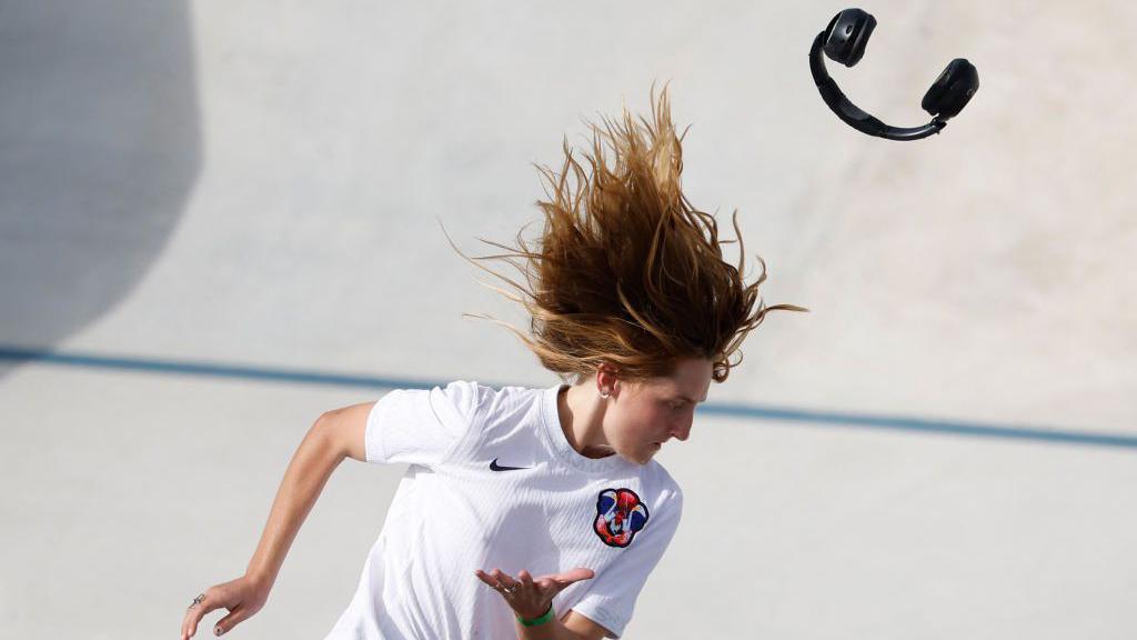 The headphones of US skater Poe Pinson fall off during the street skateboarding final