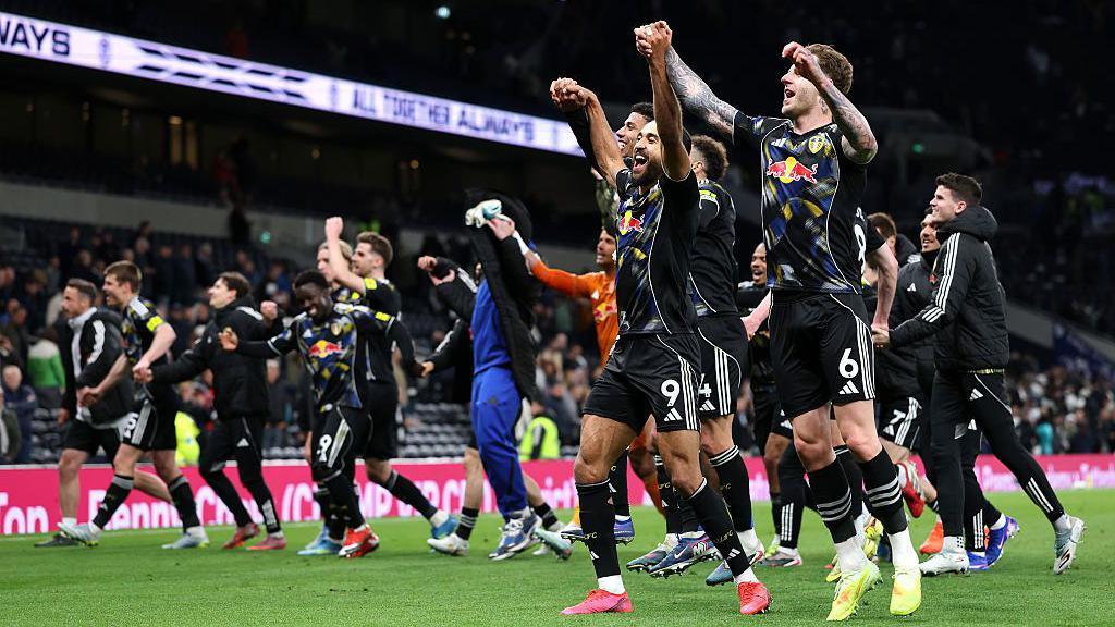 Leeds United players celebrate Premier League safety after draw against Tottenham