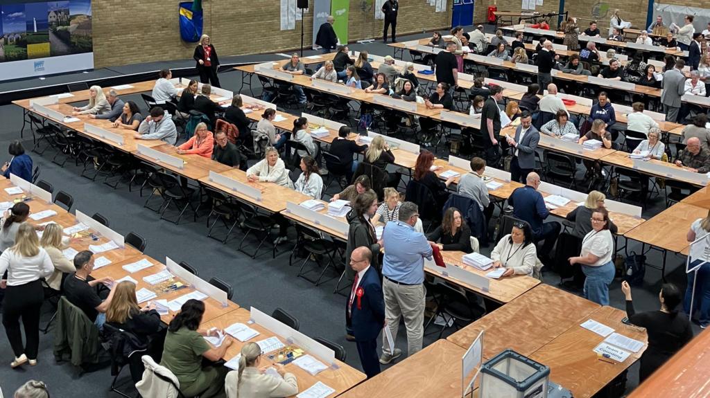 People milling and about to start counting at an election count