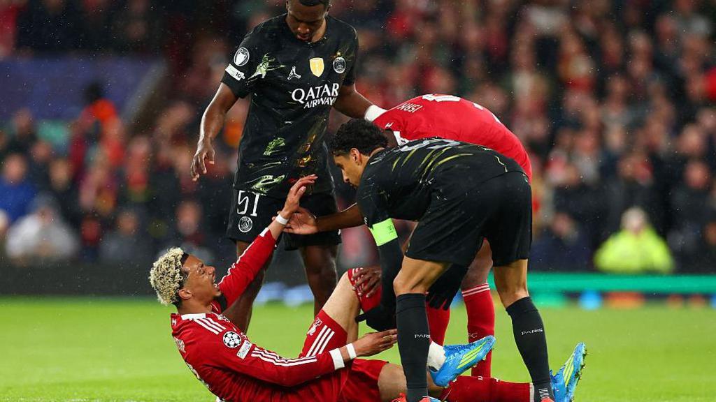Ekitike lies on the turf in pain as concerned players from both Liverpool and Paris St-Germain tend to him