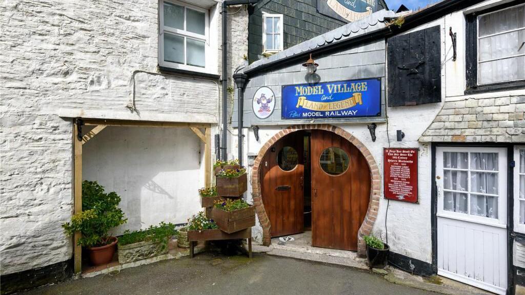 The entrance to Polperro Model Village, through two predominantly circular doors in the corner of a village terrace