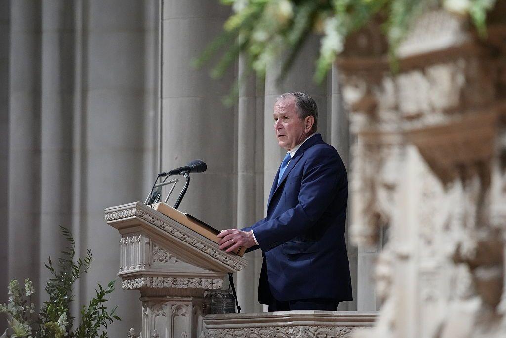 George W Bush at a podium speaking at Cheney's funeral