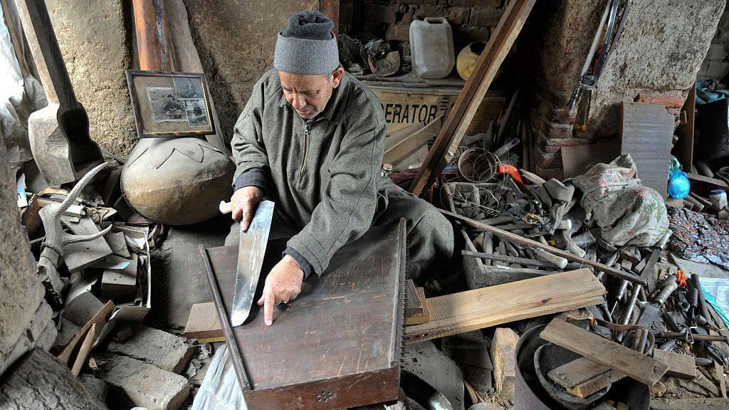 Ghulam Mohammad Zaz, one of the renowned 'Santoor' makers in the valley, works on a sitar (musical instrument) body at his one-room workshop in Downtown area of Srinagar, on February 20, 2016 in Srinagar, India.