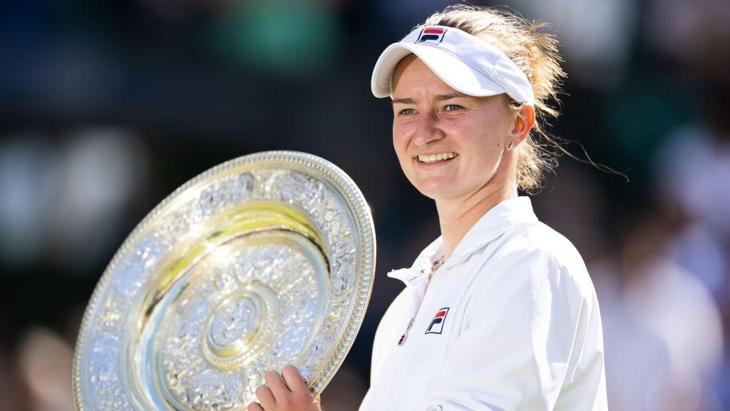 Barbora Krejcikova shows off the Venus Rosewater Dish after winning the women's singles title at Wimbledon 2024