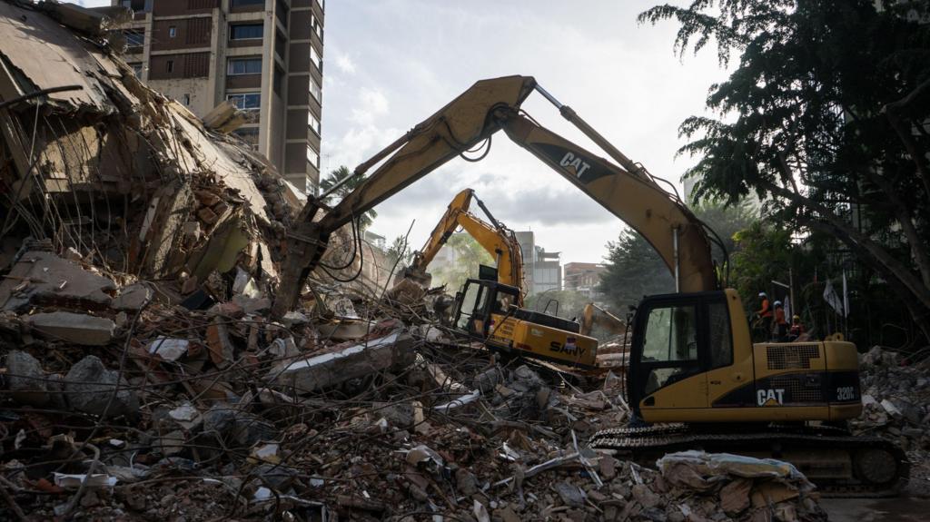 Rescue workers work at a building damaged by an earthquake in the Altamira area of Caracas, Venezuela.